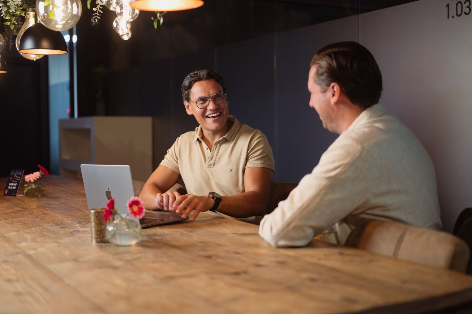 Thomas van der Kuijl in gesprek aan tafel, met zijn laptop open